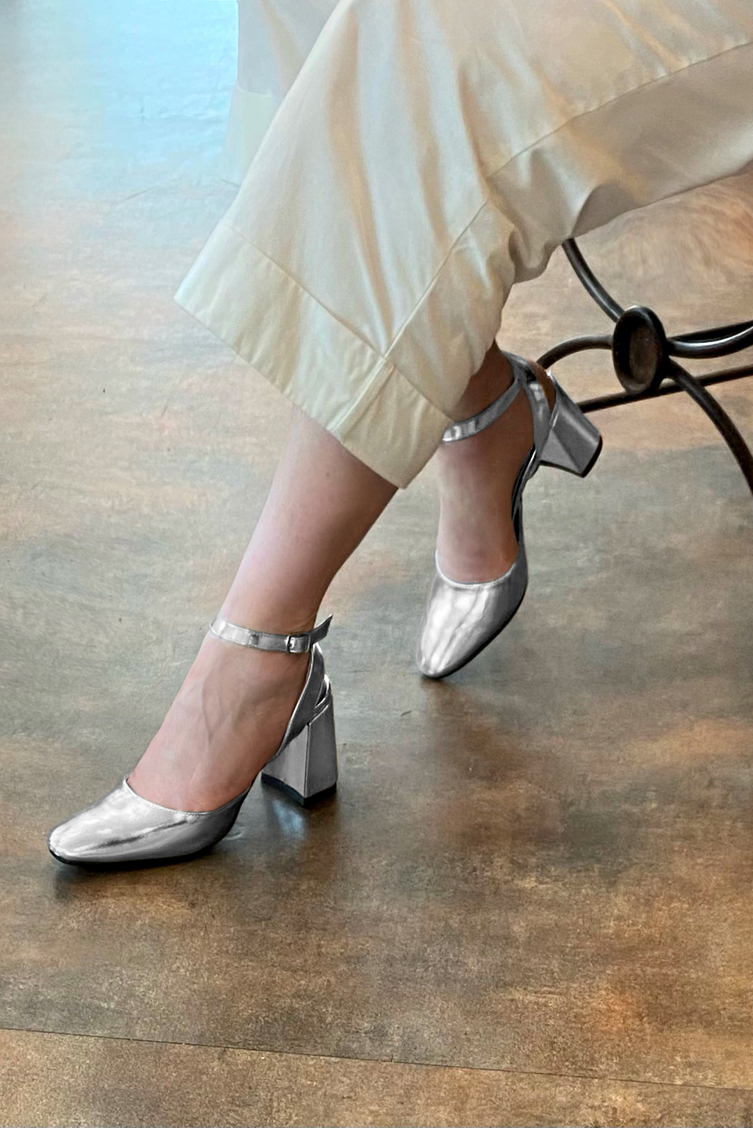 Light silver women's open back shoes, with an instep strap. Round toe. High flare heels. Worn view - Florence KOOIJMAN